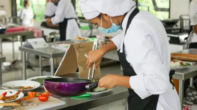 Hospitality students plating dishes in a teaching kitchen during a culinary workshop