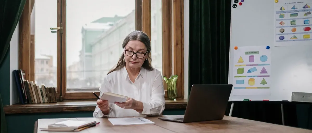 Ontario teacher reviewing SHSM programme requirements at a desk with a laptop and a printed guide
