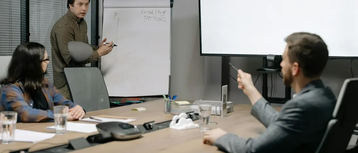 Professionals collaborating around a boardroom table during a business strategy presentation