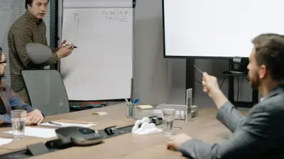 Professionals collaborating around a boardroom table during a business strategy presentation